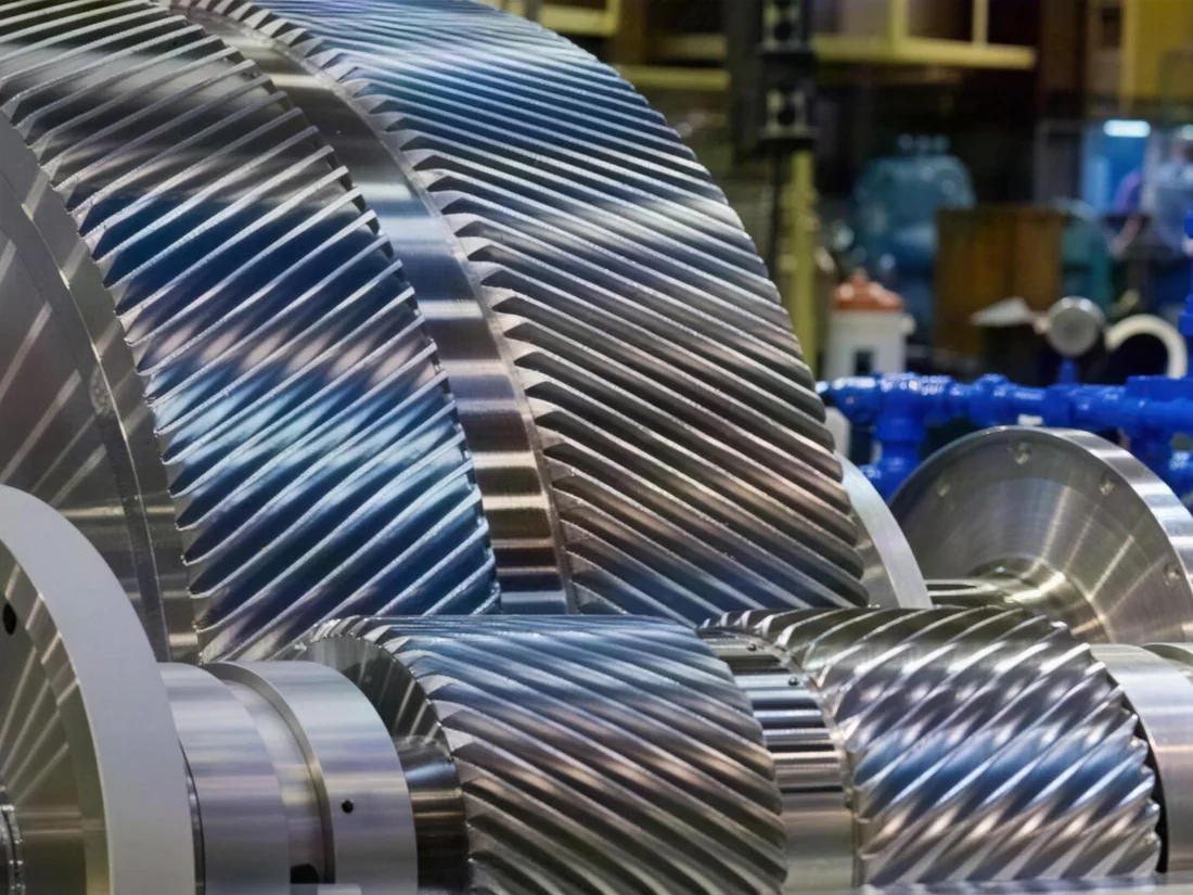 Industrial gearbox with the casing lifted, showing the double-helical gear train