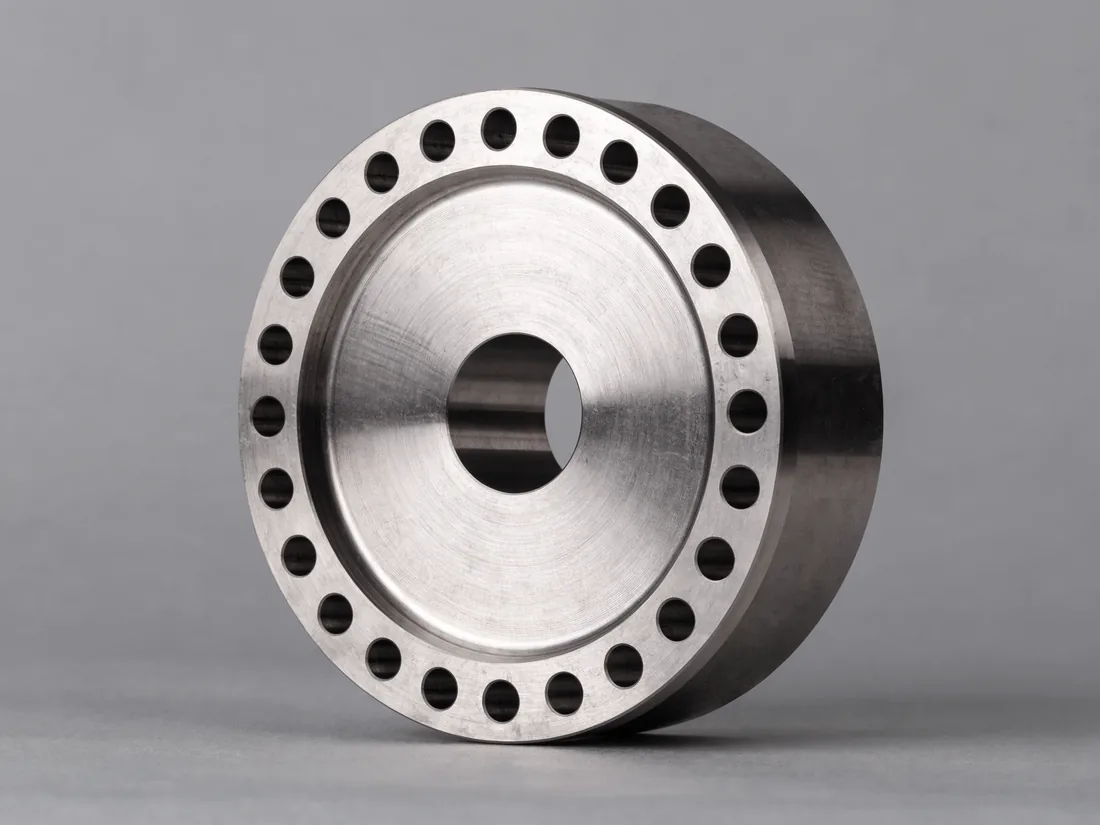 Machined generator end cap with a central bore and fixing holes