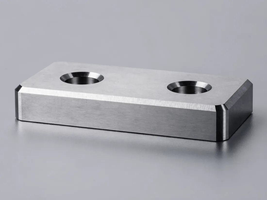 Machined steel wear pad with counterbored fixing holes