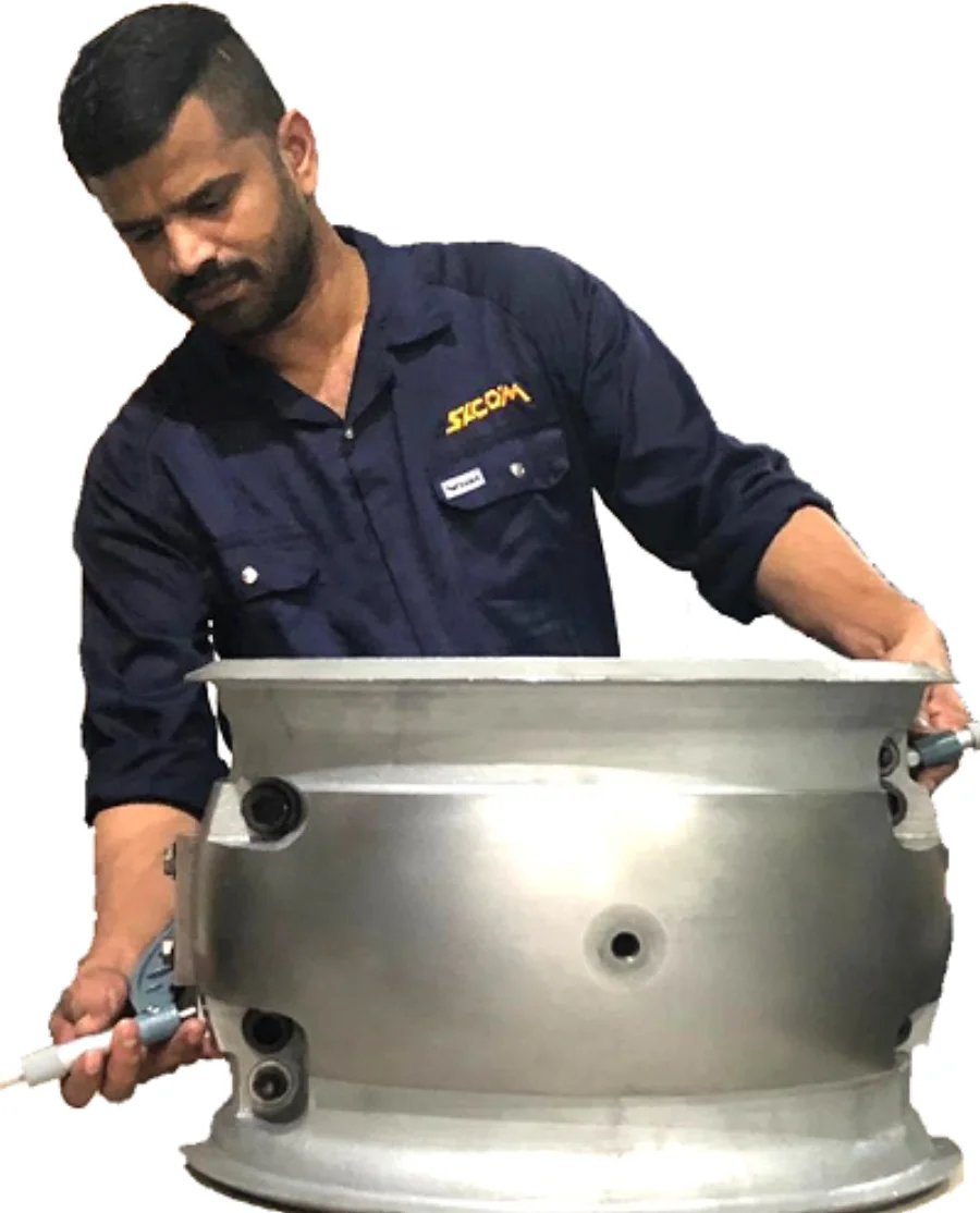 A Shaheen Arabia technician measuring the outside diameter of a machined rotating-equipment housing with a micrometer at the Jubail facility